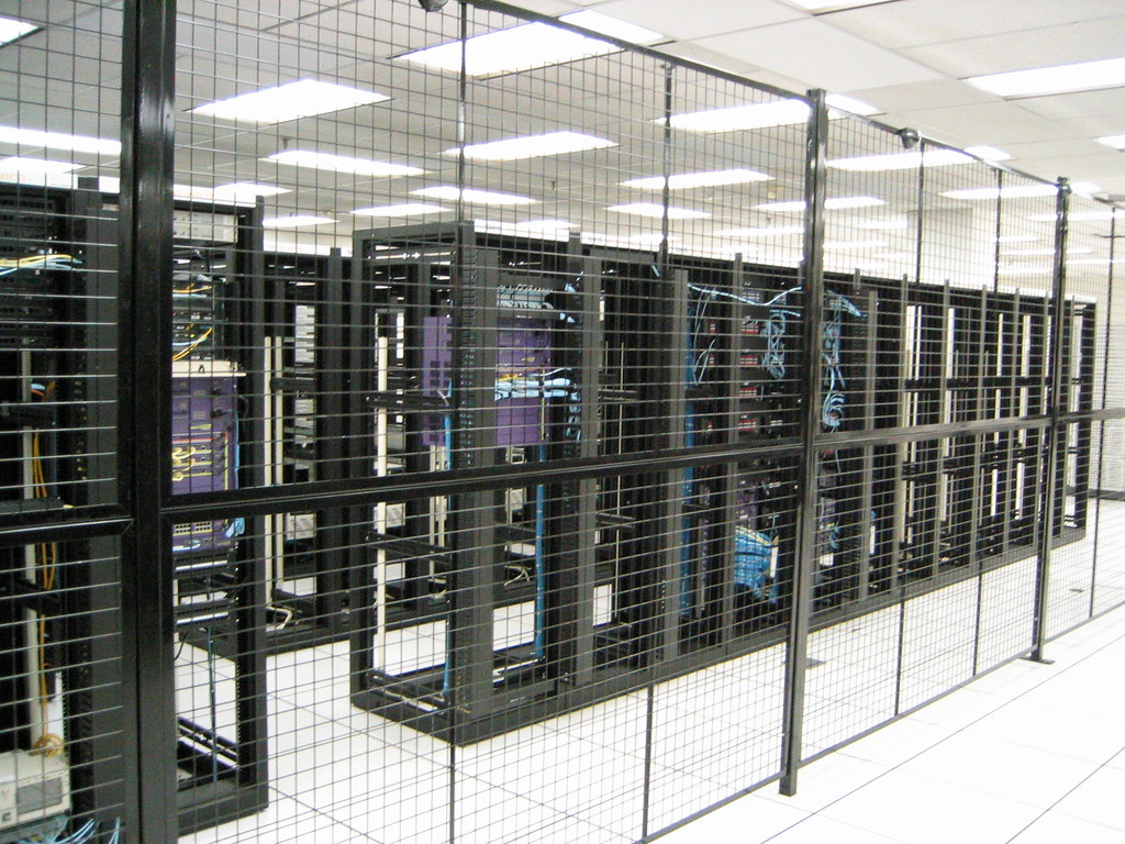 Sala server di un data center con armadi di rete illuminati, che rappresenta l'infrastruttura da proteggere in una strategia di cyber security per PMI.